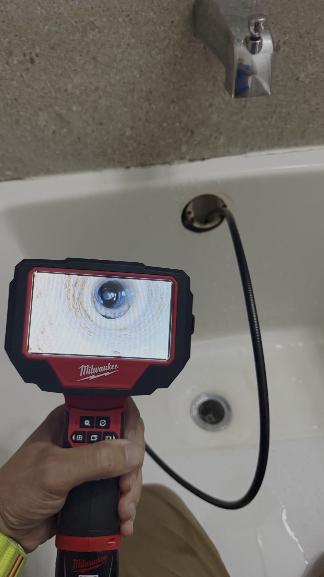 Professional plumber performing a diagnostic camera inspection on a residential sewer line