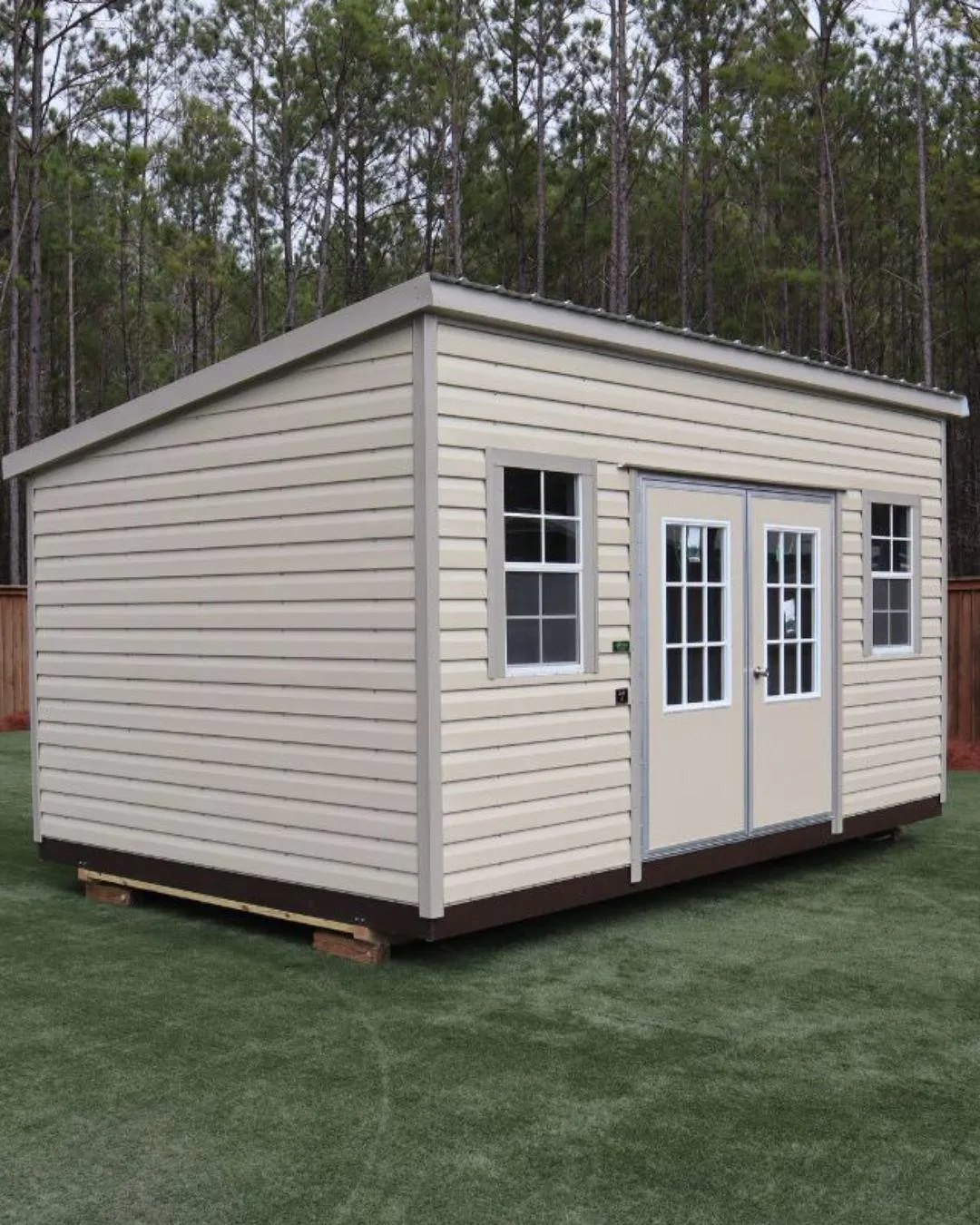 a red and green shed sitting in the middle of a field