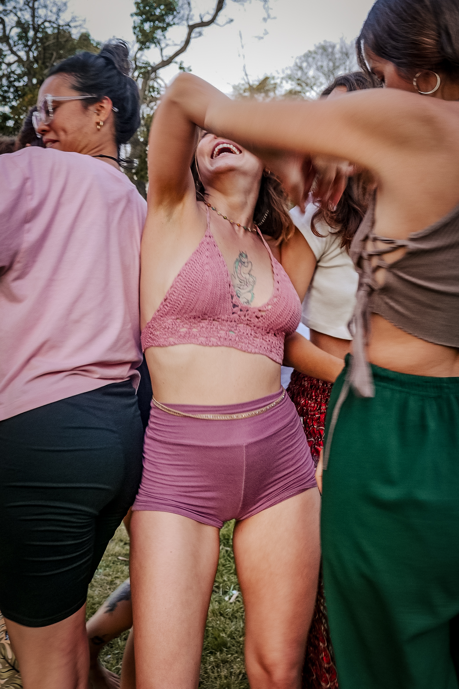 a group of people sitting on top of a lush green field