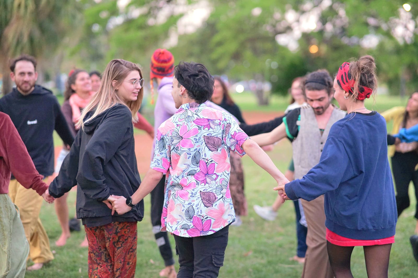 a group of people sitting on top of a lush green field