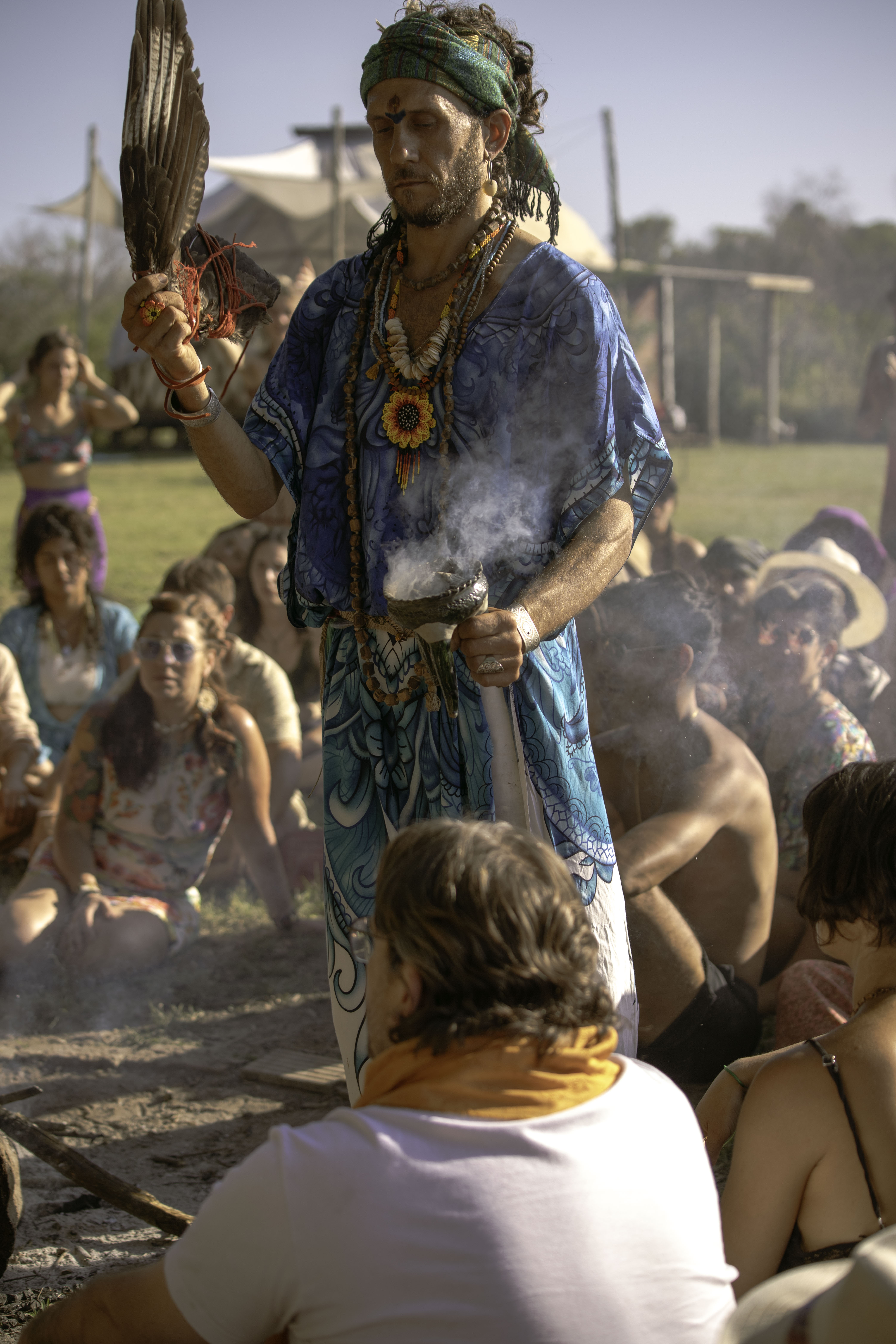a group of people sitting on top of a lush green field