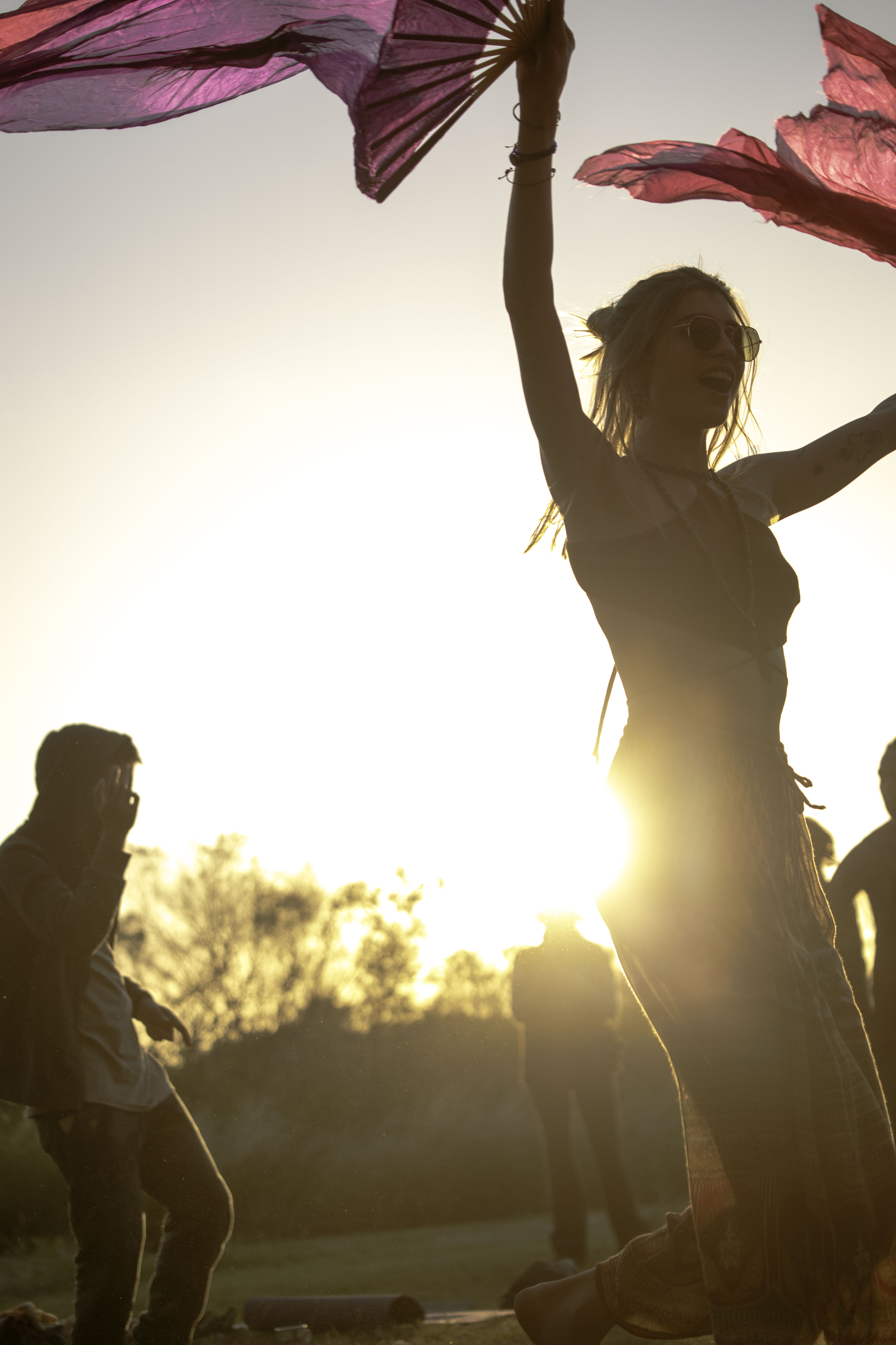 a group of people sitting on top of a lush green field
