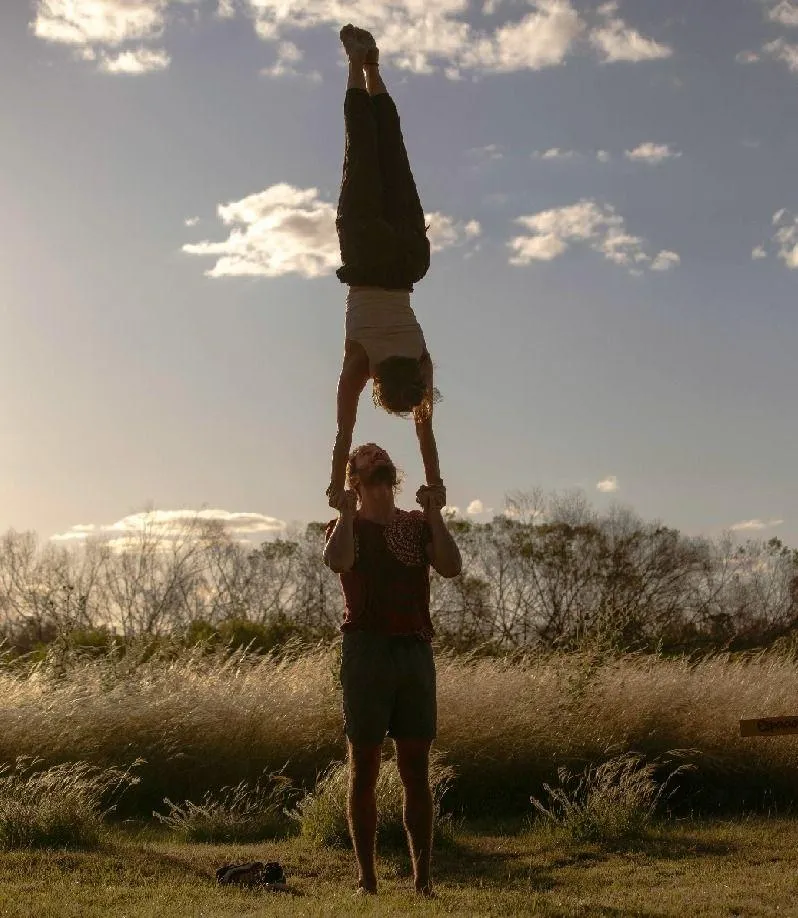 a group of people sitting on top of a lush green field
