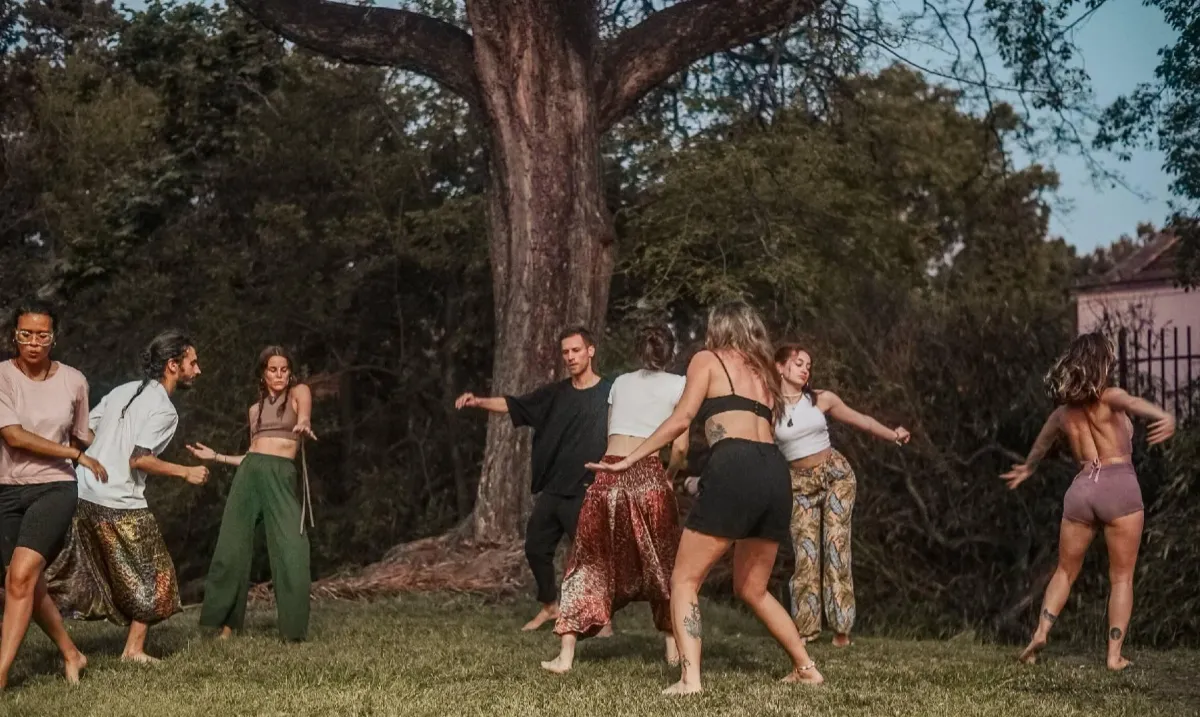 a group of people sitting on top of a lush green field
