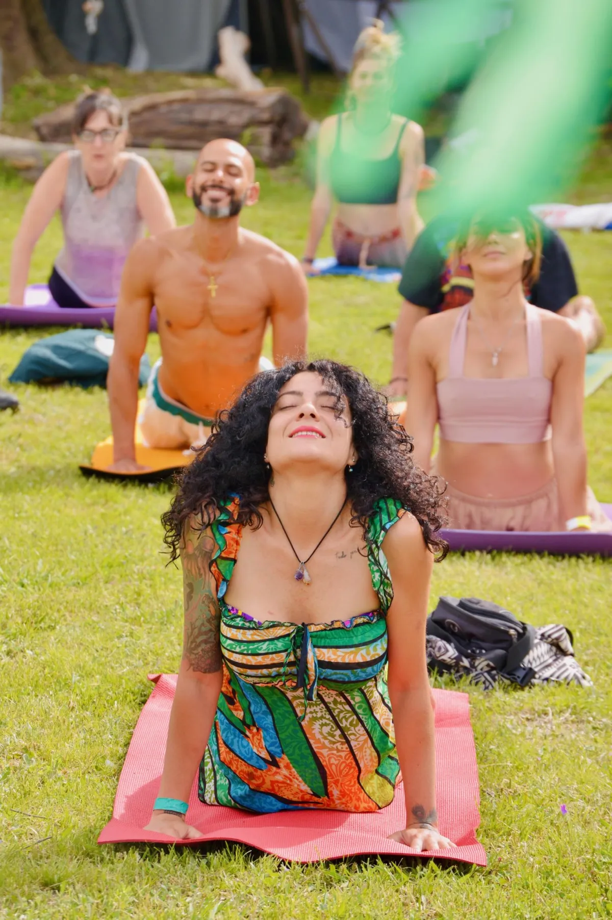 a group of people sitting on top of a lush green field