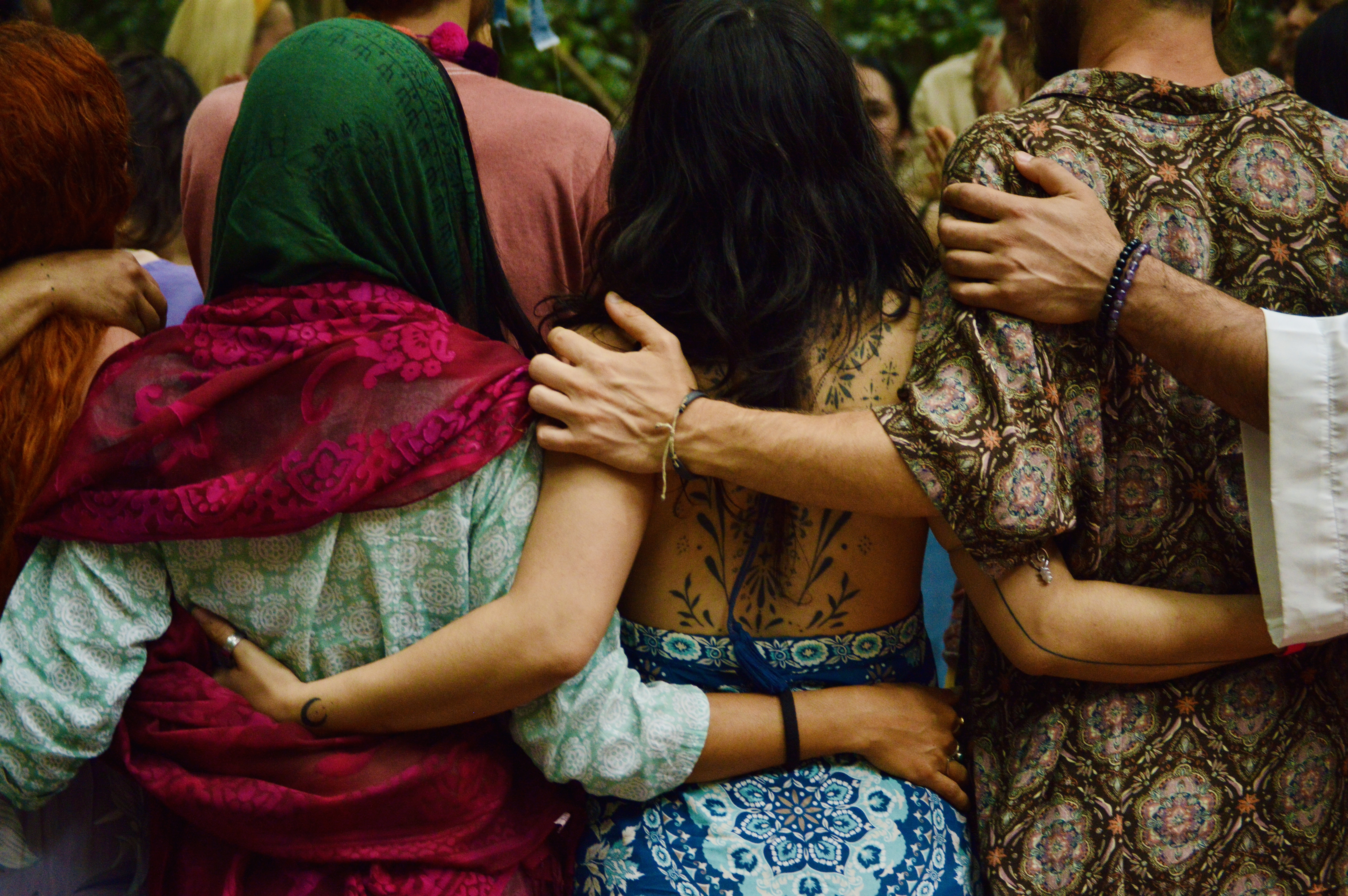 a group of people sitting on top of a lush green field