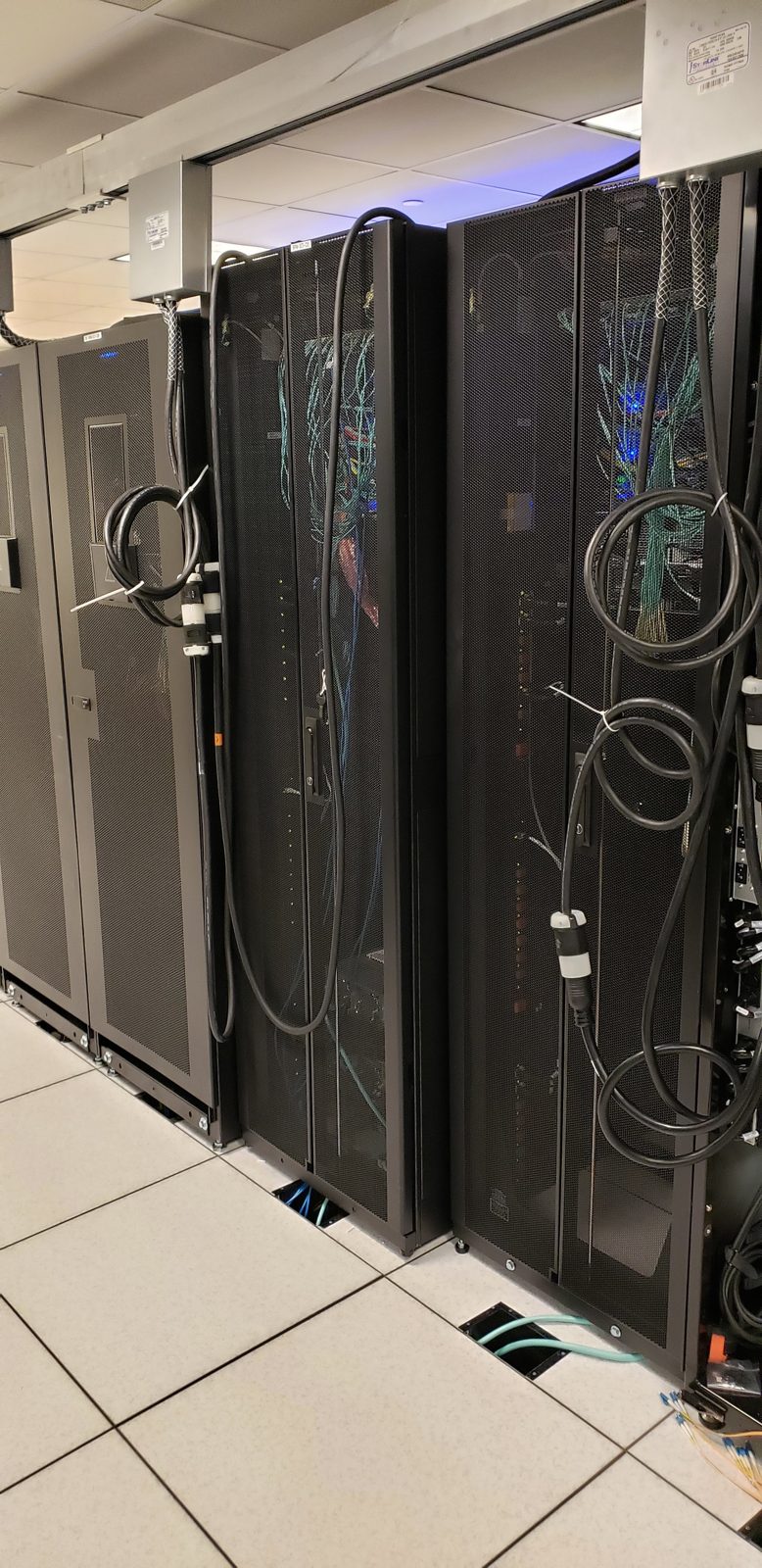 Pair of data hall cabinets installed on raised floor by All Soul Tech