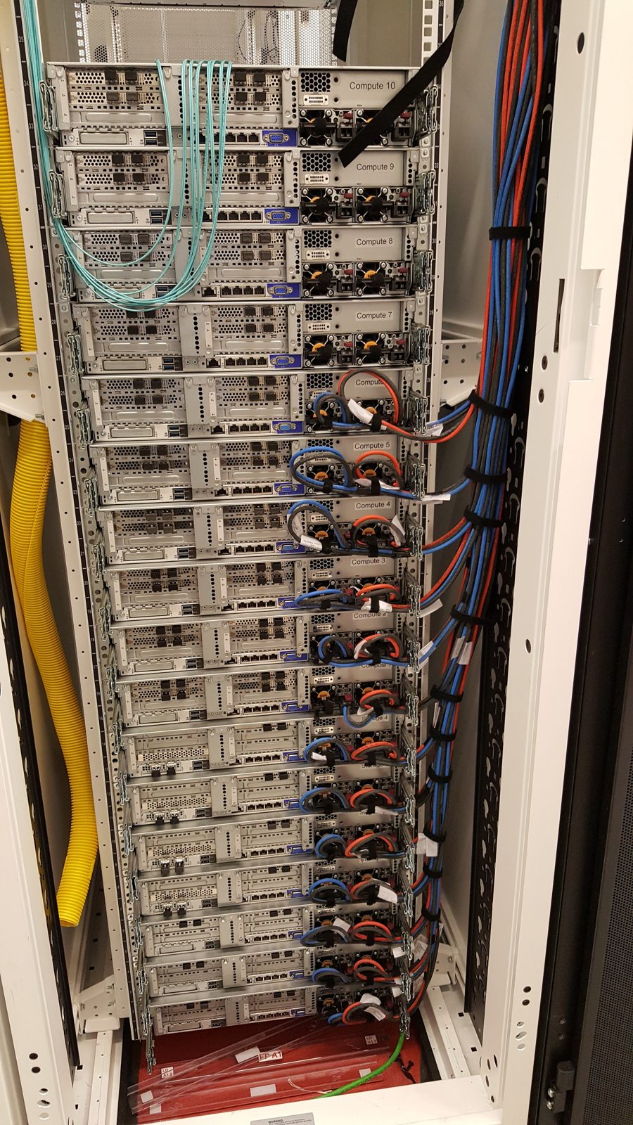 Server rack with neatly dressed aqua fiber patching by All Soul Tech
