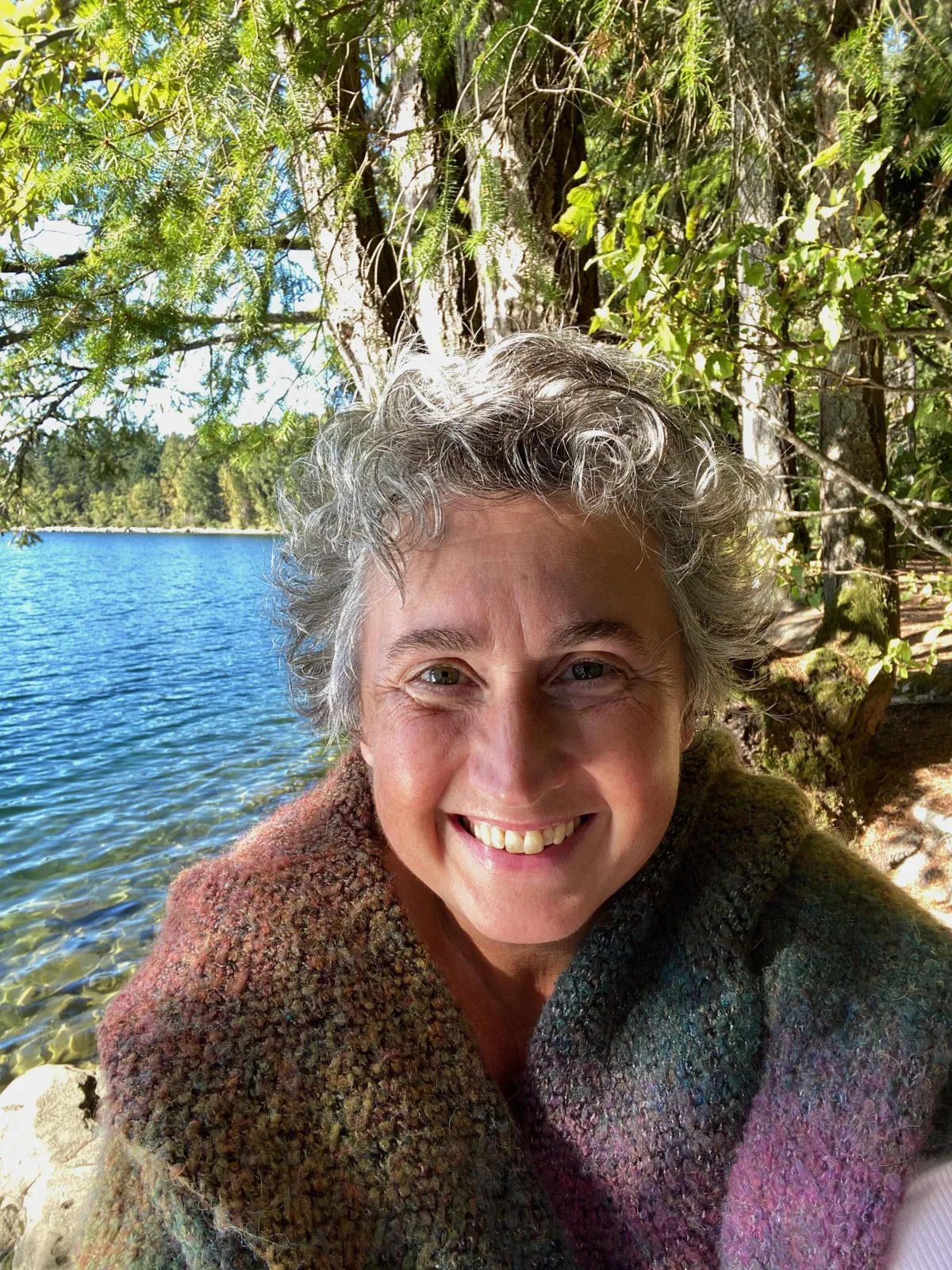 Melanie Gillespie, MBA, global expert on the gifted brain, shown with a lake and trees in the background