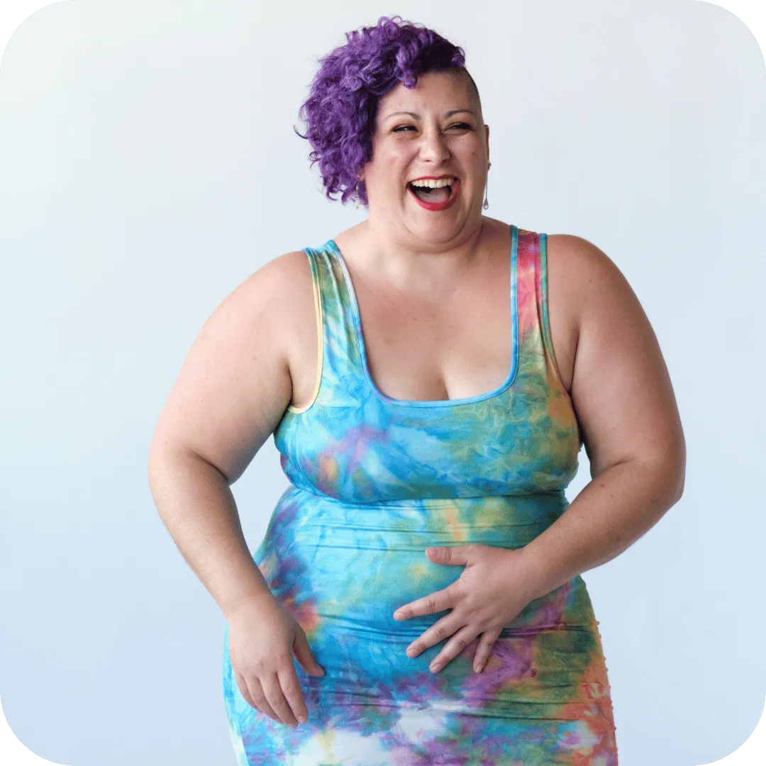 Jess DuBose smiling in a colorful dress against a white background