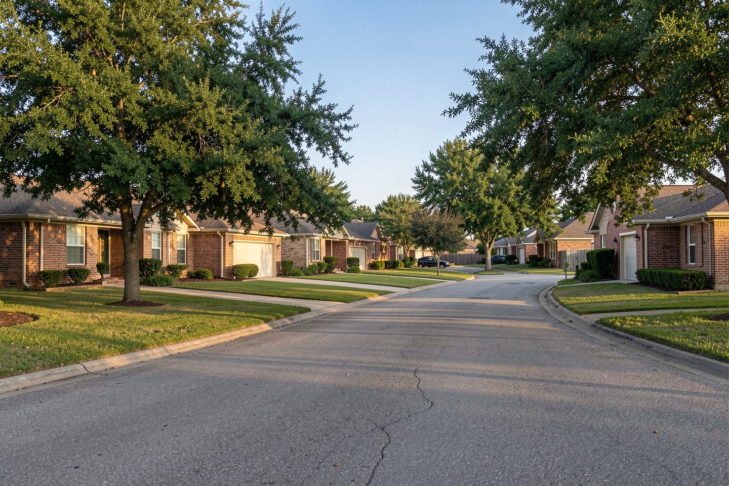 Quiet Garland, TX street with single-story brick ranch homes and mature shade trees