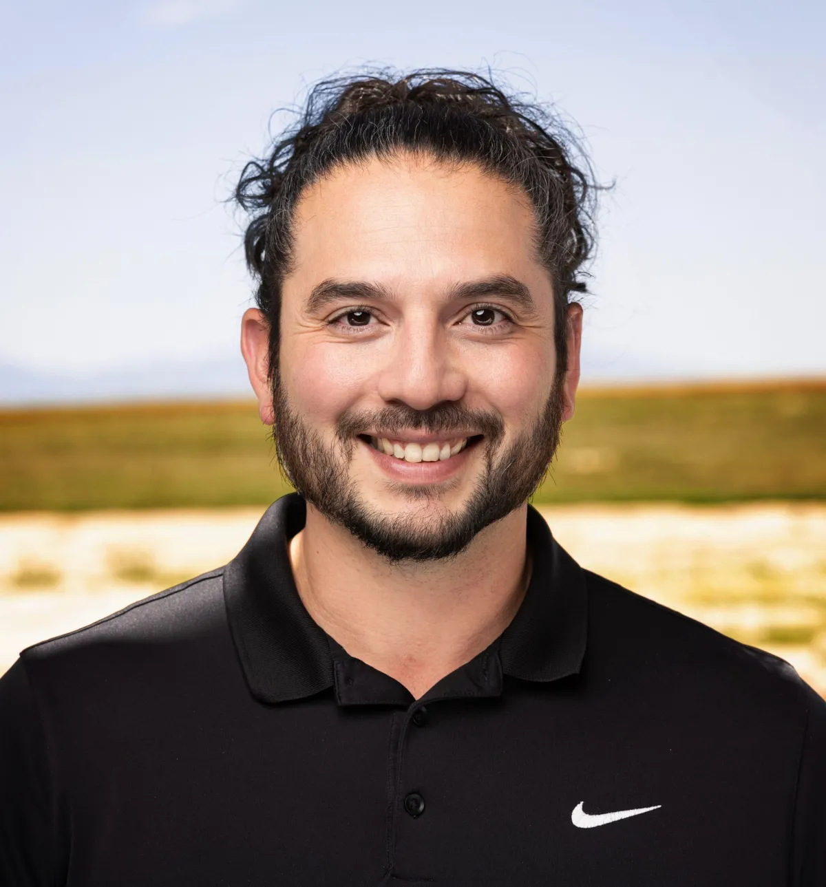 James Romero, trusted mortgage broker in Pueblo, Colorado, smiling in front of a home he helped finance.