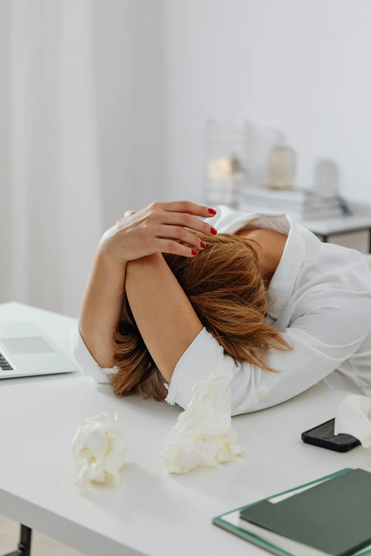 Woman with head down on desk.
