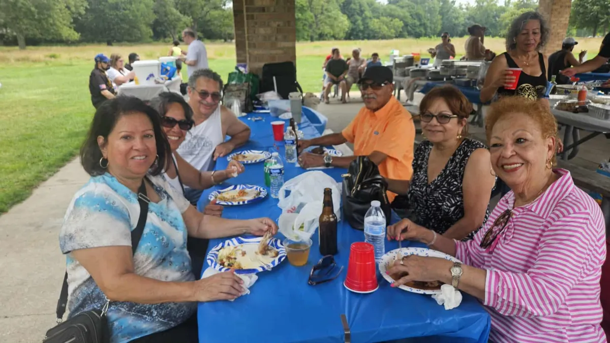 A large family poses for a group portrait outdoors.