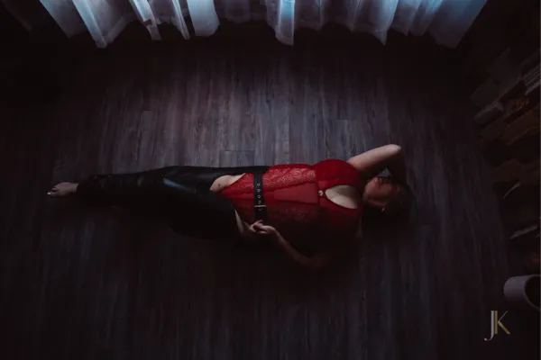 Woman in a red body suit and chaps lying on the ground with her arm above her head | Jessica Korff Studio, Tucson, AZ