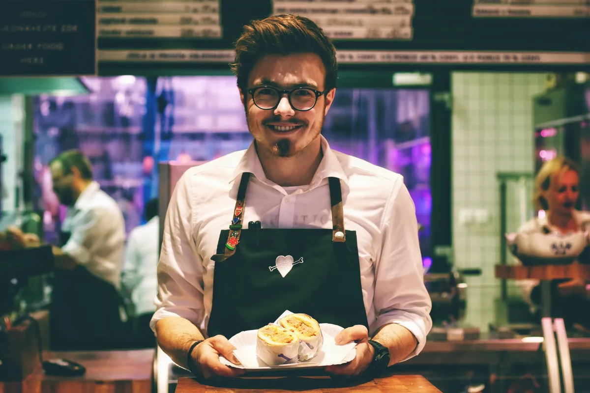 Restaurant owner smiling while serving plates