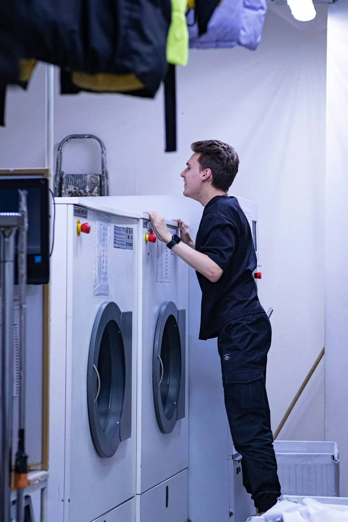 Laundry business worker loading commercial washers