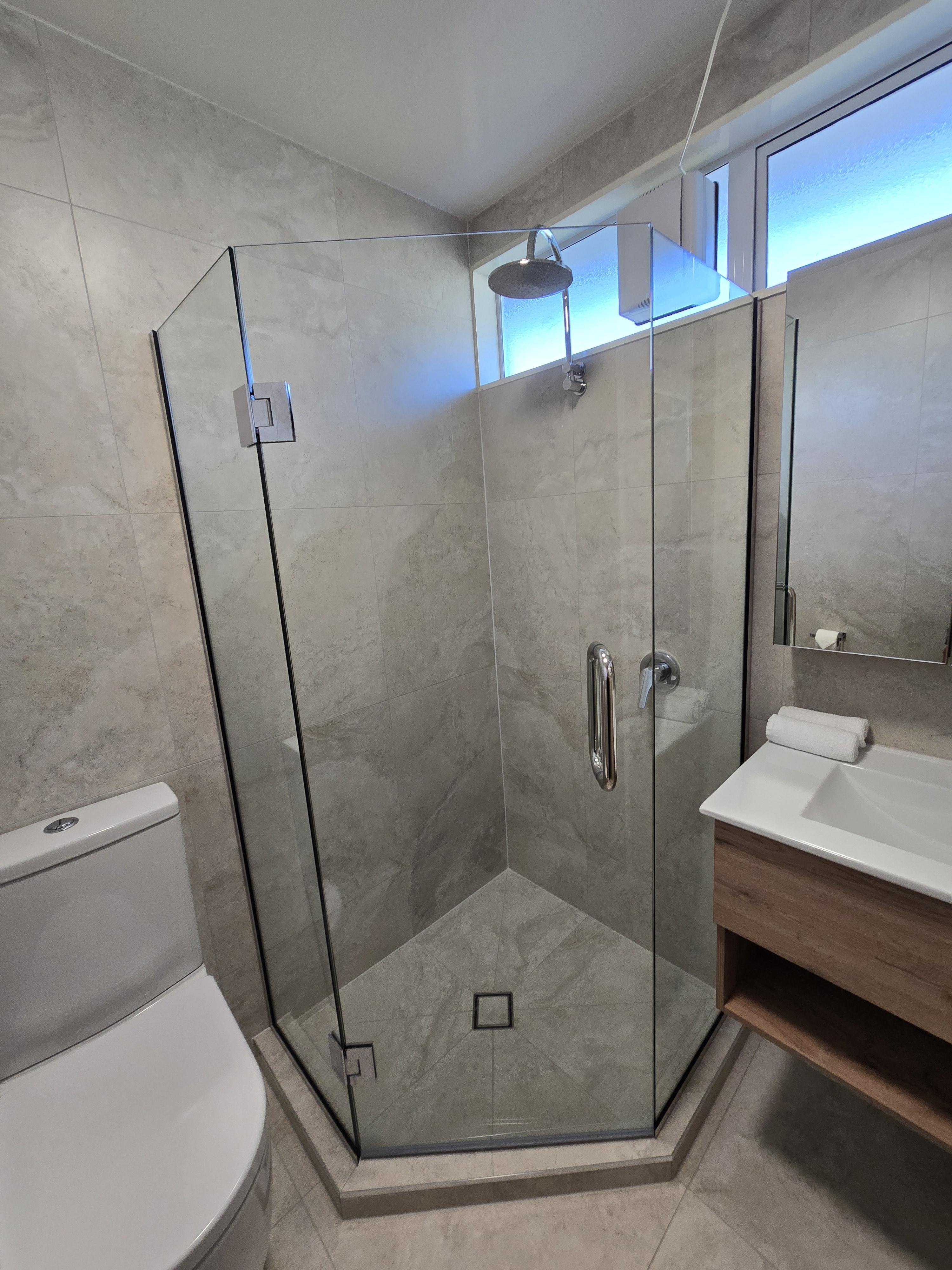 Modern bathroom renovation with glass shower and tiled walls by Opuke Small Builds in Methven