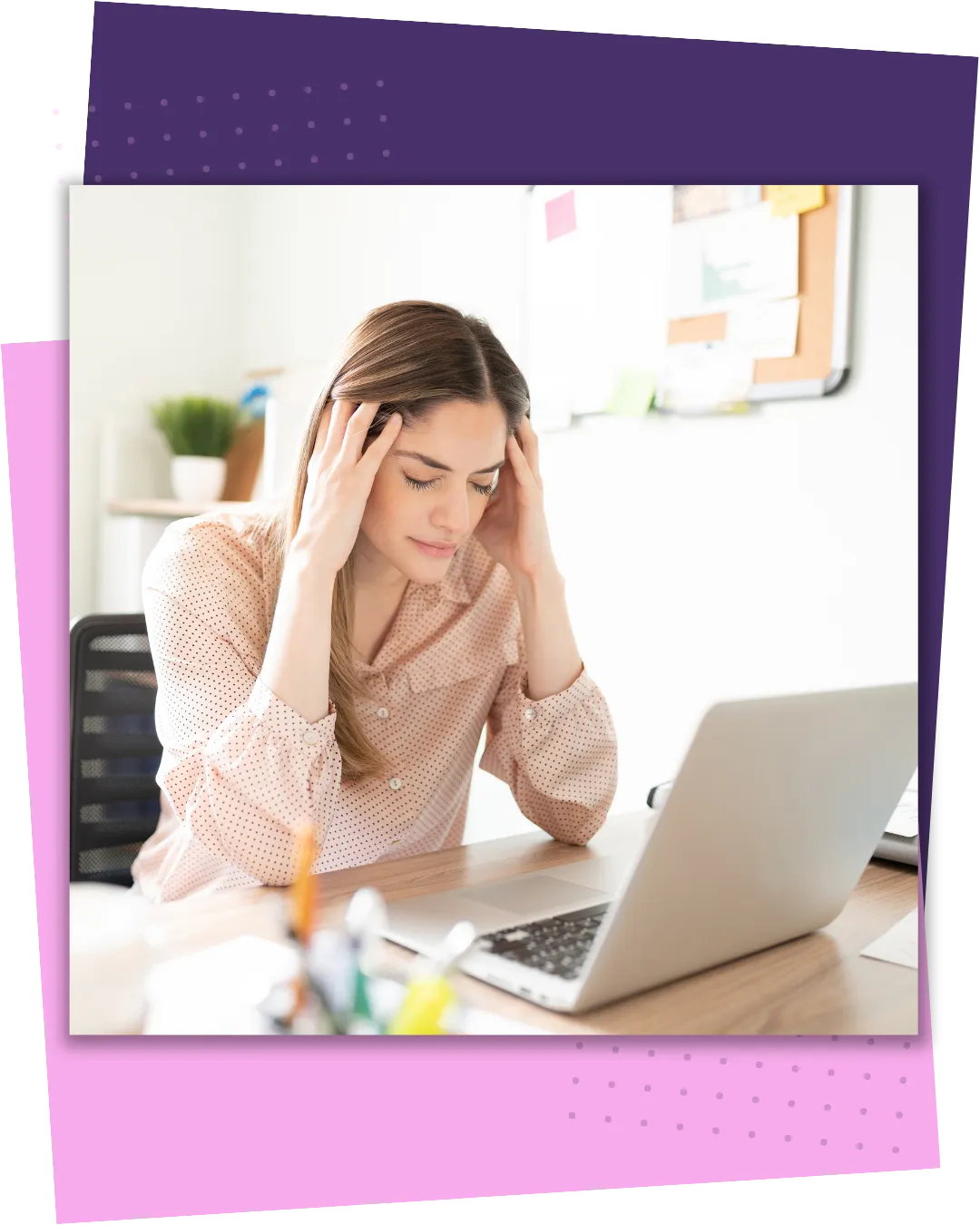 Person sitting with head in hands looking overwhelmed in front of laptop in the office.