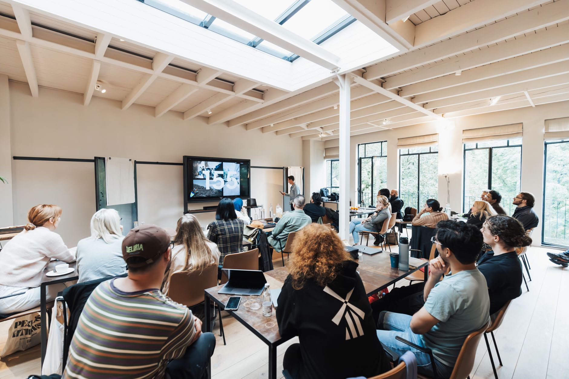 A diverse group of adults attending a business workshop in a bright modern event space.