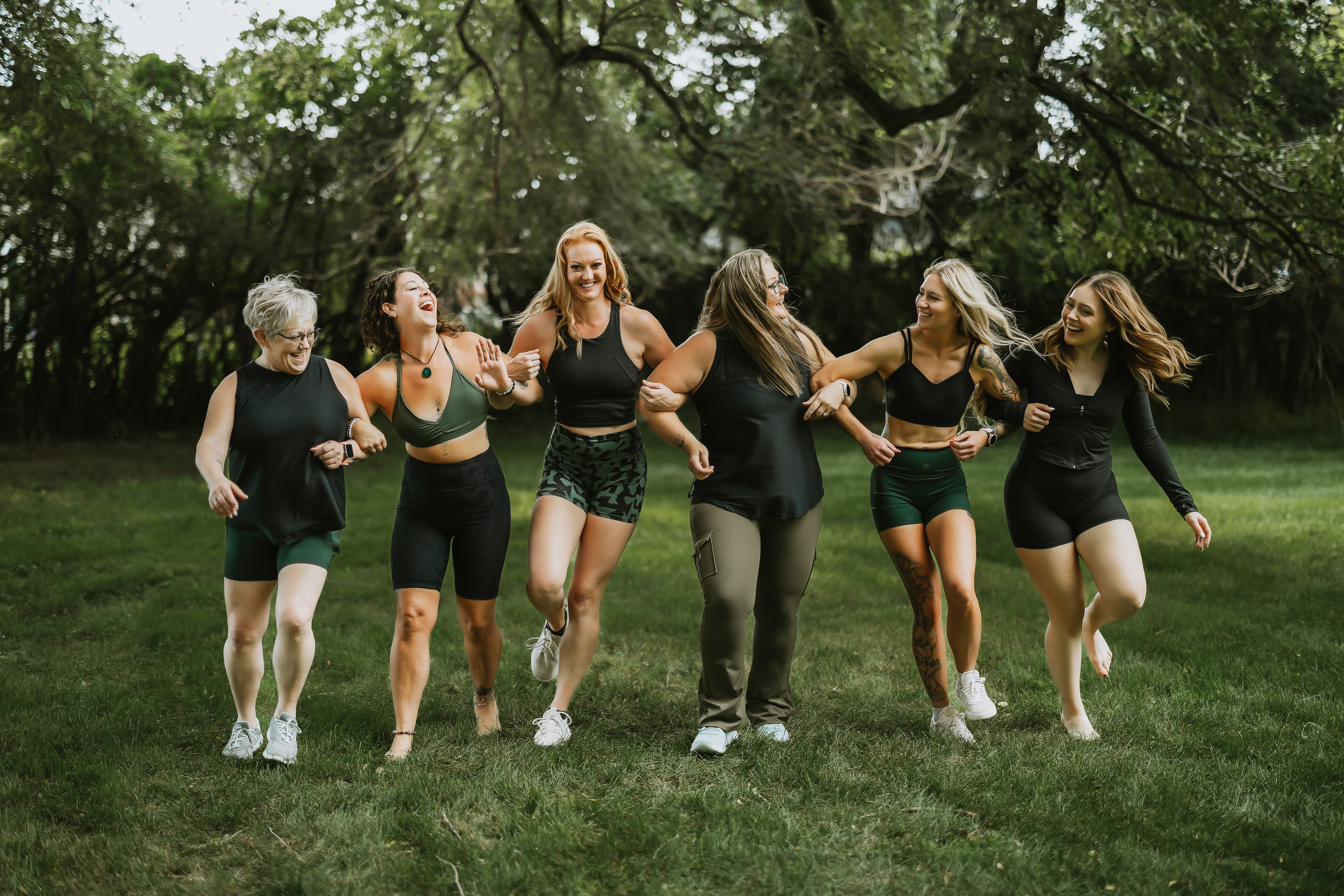 Two friends smiling and dancing together at a fitness class