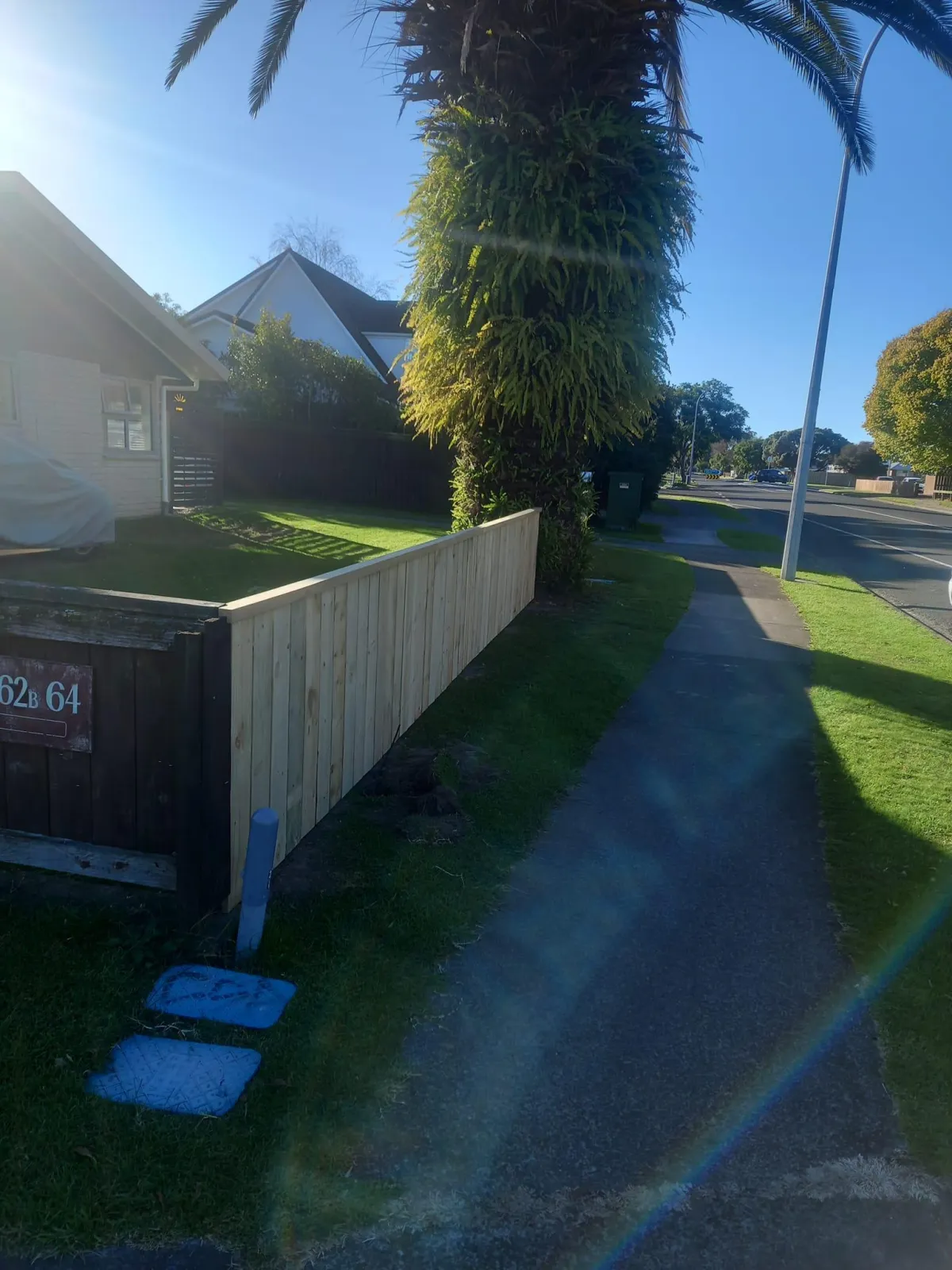 Side-yard timber fencing with angled corner near a front garden