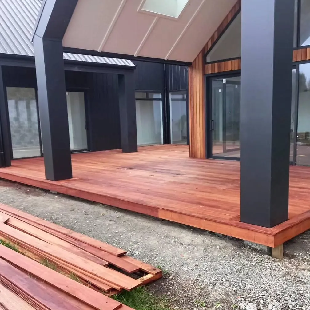 Large hardwood deck construction beside a modern home