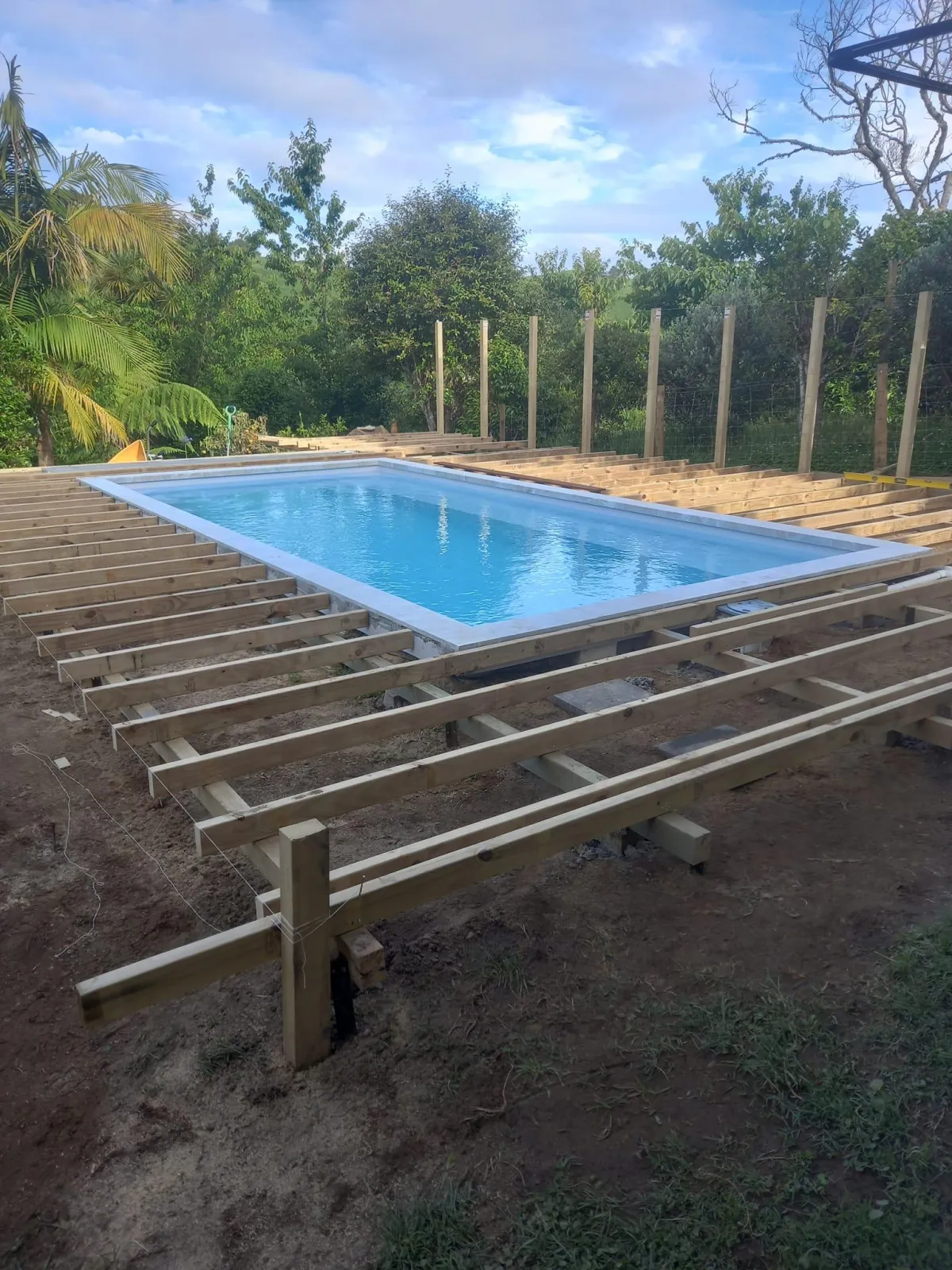 Timber-framed pool fencing with in-progress decking structure