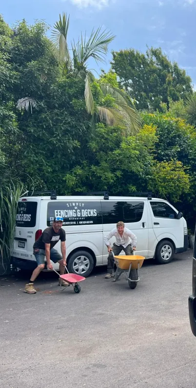 Simply Fencing and Decks van and team on-site with wheelbarrow and gear