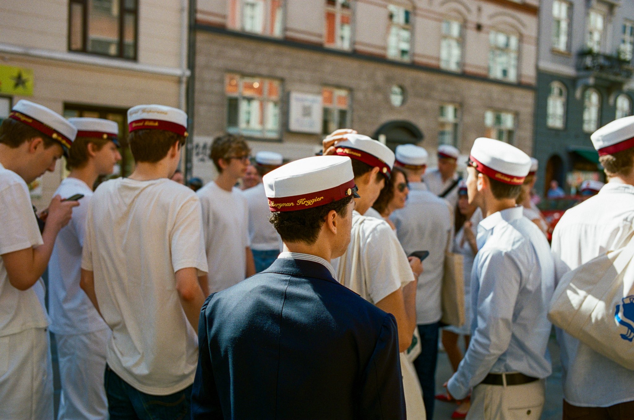Men standing around wearing white hats.