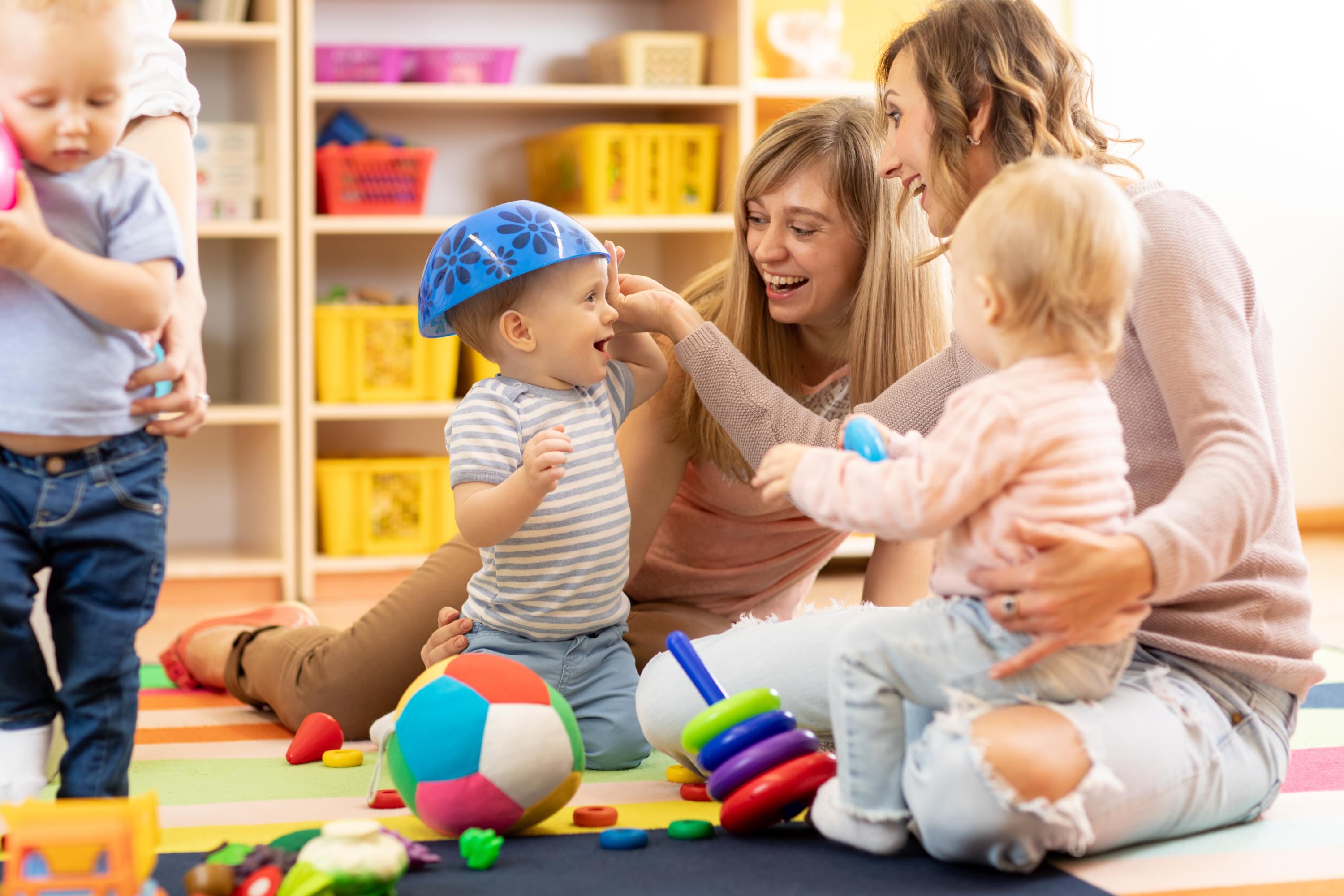 2 mommies and their kids playing in a playroom