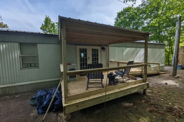 Covered deck outdoor living space attached to mobile home