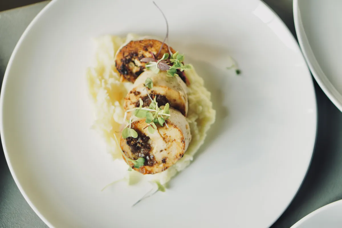 Chef-prepared meal plated with artistic presentation in a fine dining environment.