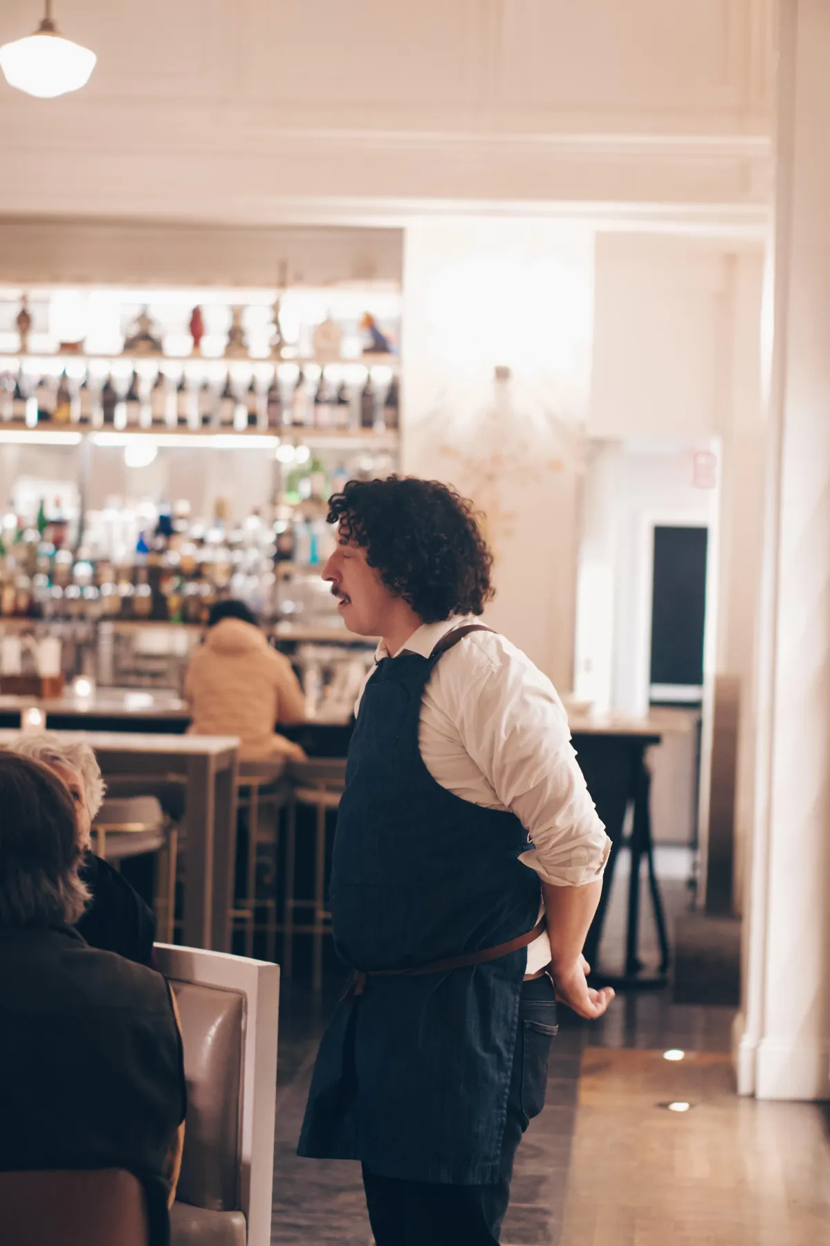 Candid moment of a server interacting with guests during service.