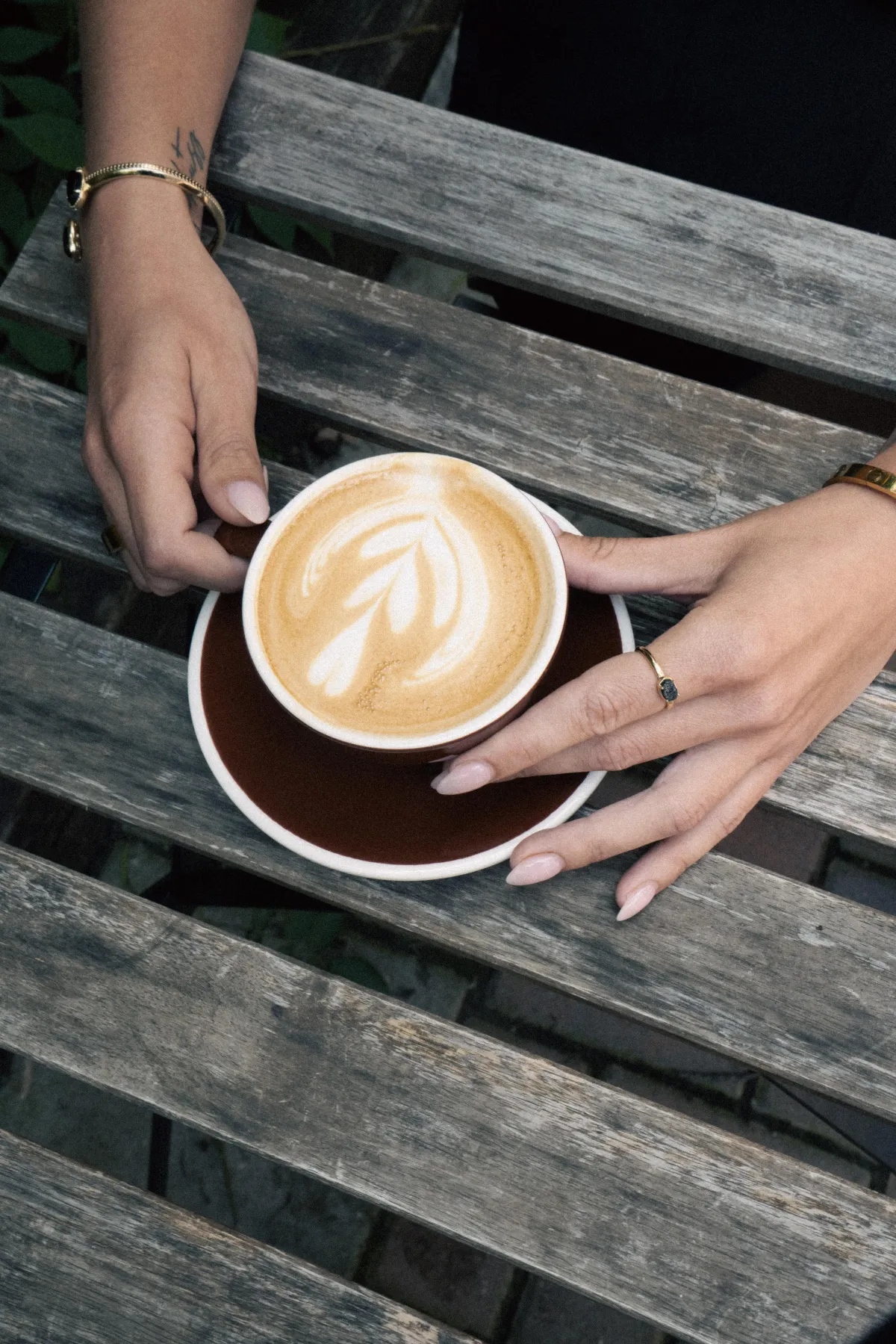 Takeaway coffee cup held by a guest outside a boutique café, capturing an on-the-go lifestyle vibe.