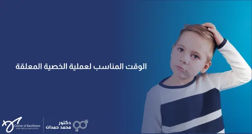 تصميم بخلفية متدرجة من الأزرق الداكن إلى الأزرق الفاتح، يتضمن على اليمين صورة فوتوغرافية لطفل صغير يميل برأسه ويضع يده فوق شعره بملامح وجه حائرة أو متسائلة. على اليسار، يظهر نص باللون الأبيض: "الوقت المناسب لعملية الخصية المعلقة". وفي الزاوية السفلية اليسرى تظهر شعارات "Center of Excellence" وعيادة الدكتور محمد حمدان.
