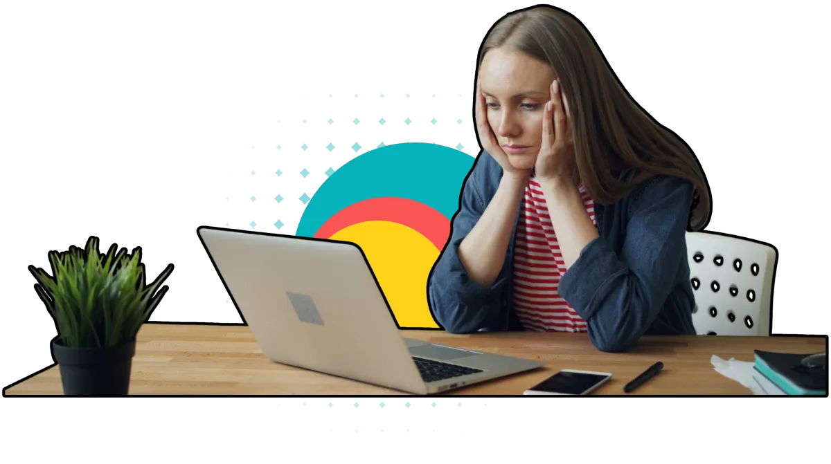 Woman sits at a wooden desk, focused on her laptop. She rests her head on her hands, looking worried.