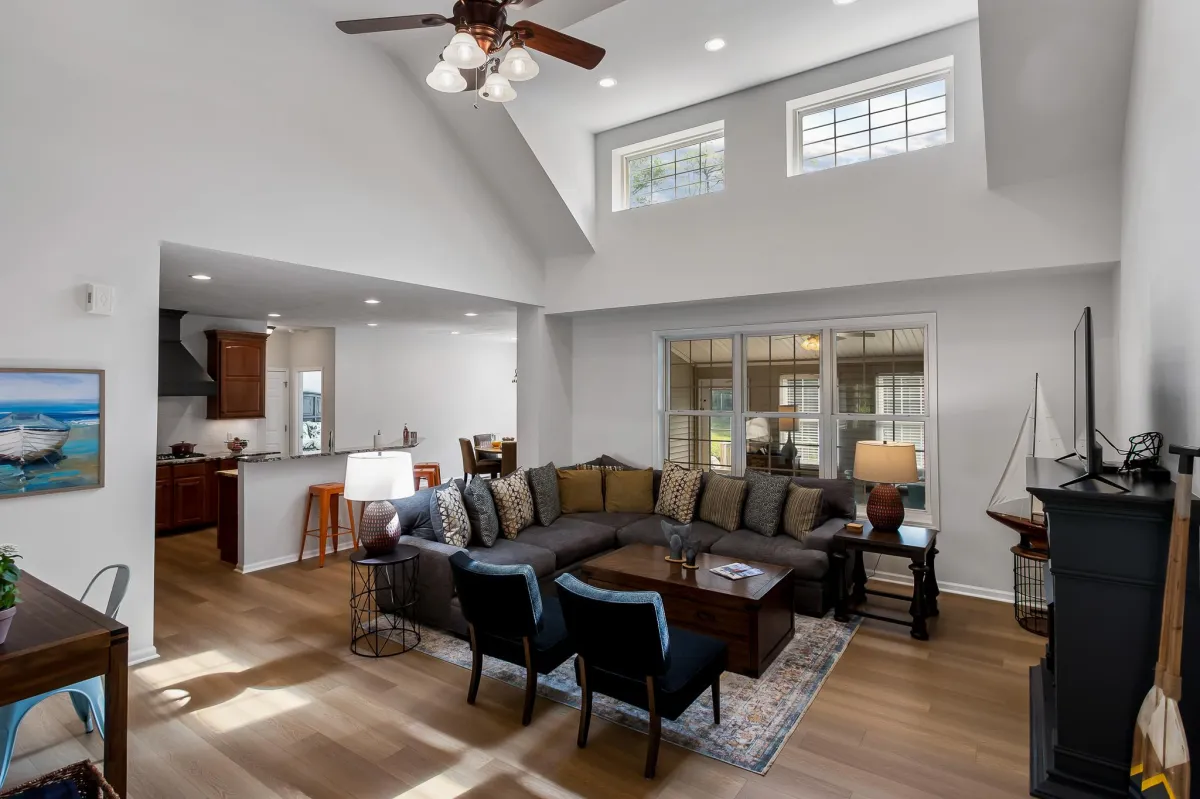 alt="Stylish living room in Holland, MI vacation home featuring a cozy fireplace and views of the backyard oasis"