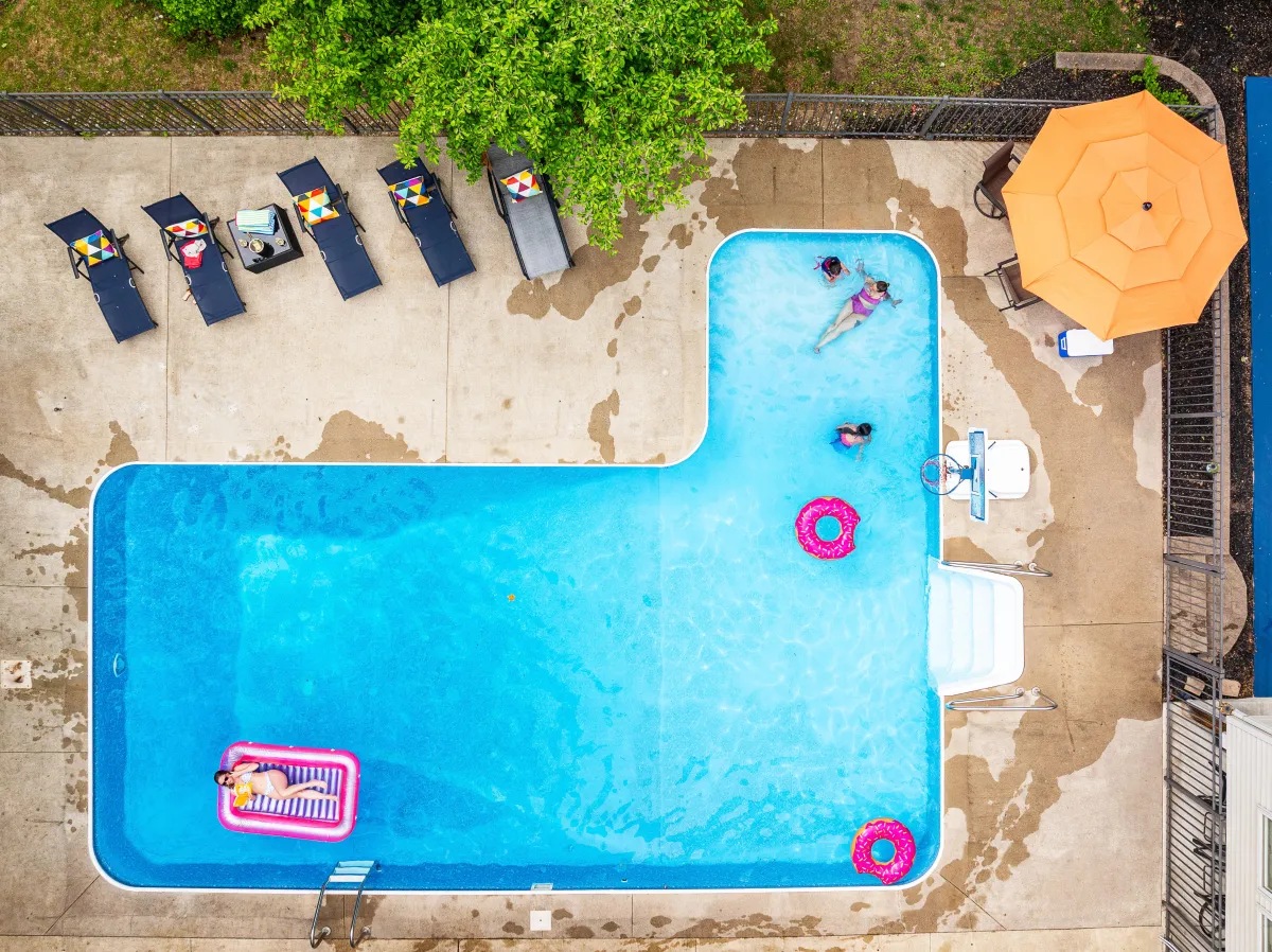 alt="Spacious inground pool with water slide at Holland, MI vacation rental, perfect for family fun and relaxation"