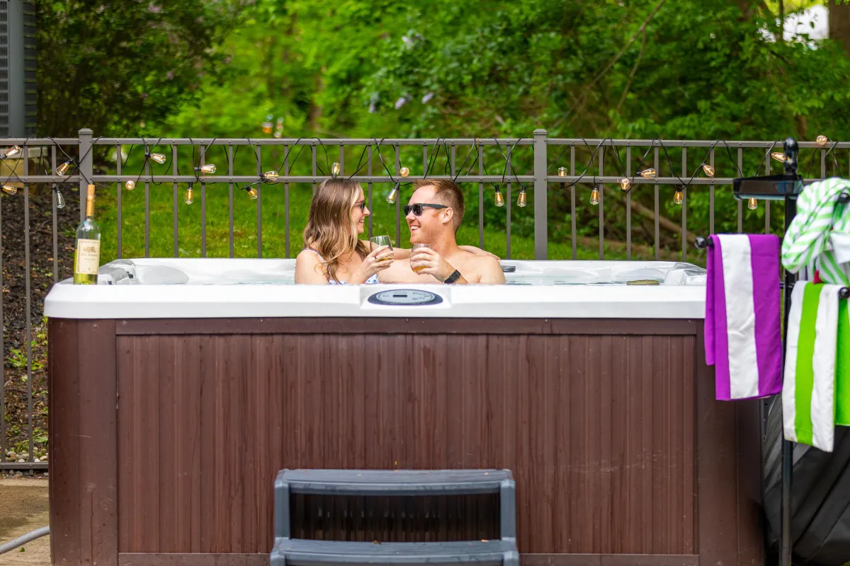 alt="Cozy outdoor fire pit area at The Monteview, Muskegon vacation home, with two guests cheersing glasses of rosé for a relaxed evening"