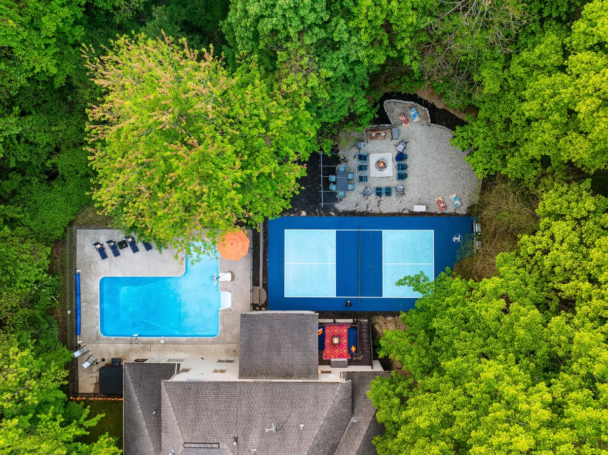 alt="The Maple property in Holland, Michigan featuring a large pool with water slide and outdoor furniture"