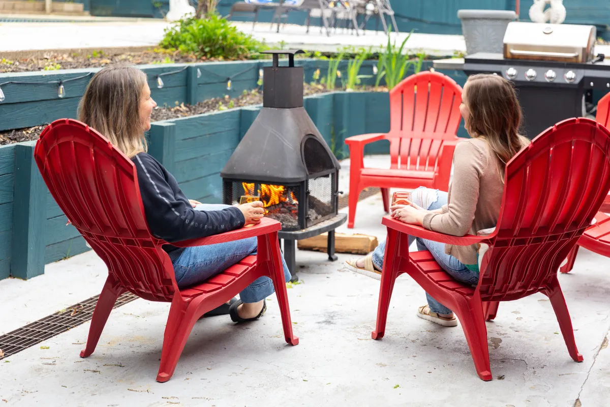 alt="Cozy outdoor fire pit area at The Monteview, Muskegon vacation home, with two guests cheersing glasses of rosé for a relaxed evening"