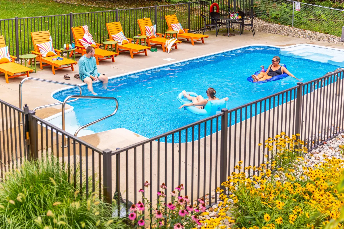 Guests floating in the private pool at Swimming in the Sunset, a luxury Fennville MI vacation rental with hot tub and backyard retreat near Lake Michigan