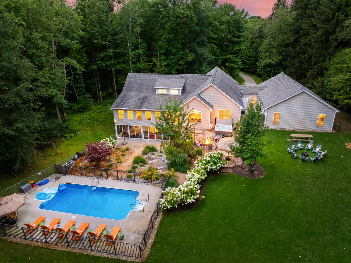 Luxury Fennville vacation rental with private resort-style pool, hot tub, and spacious backyard designed for large groups near Lake Michigan