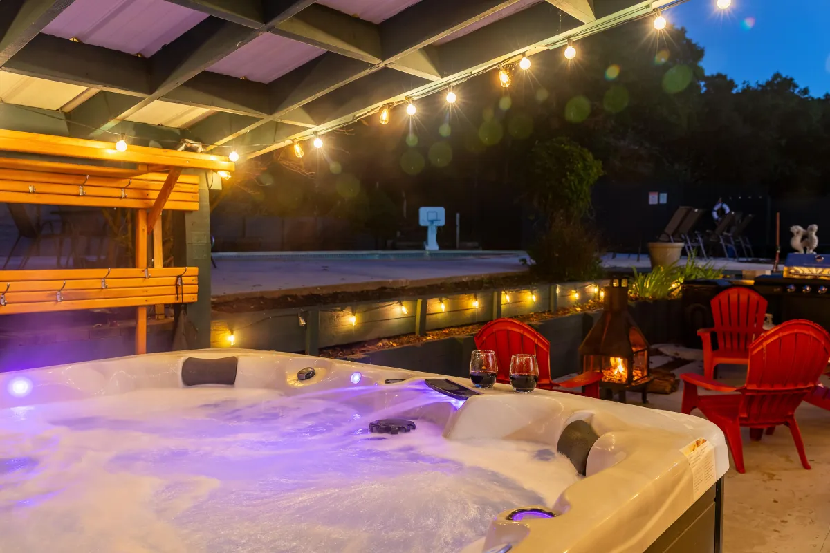 alt="Cozy outdoor fire pit area at The Monteview, Muskegon vacation home, with two guests cheersing glasses of rosé for a relaxed evening"