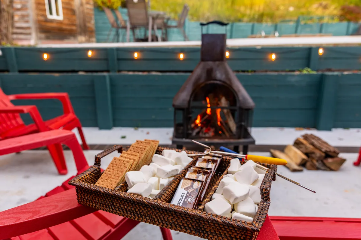 alt="Cozy outdoor fire pit area at The Monteview, Muskegon vacation home, with two guests cheersing glasses of rosé for a relaxed evening"