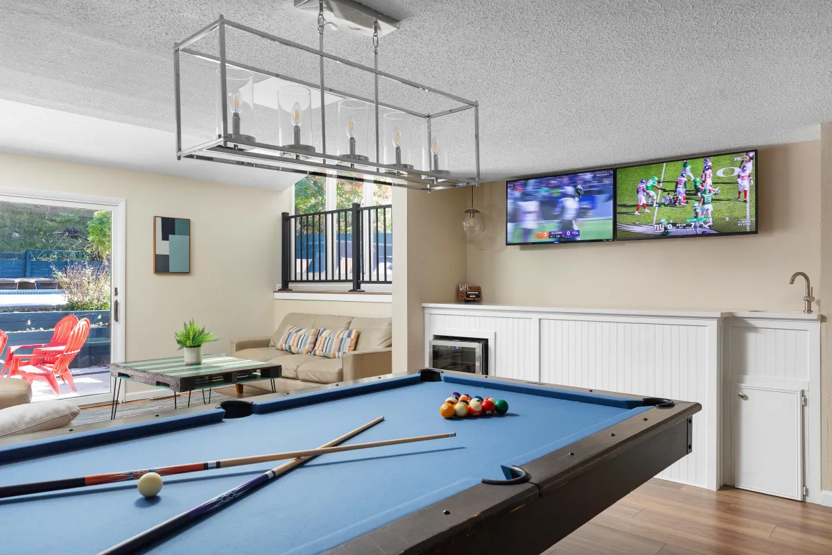 alt="Stylish wet bar and pool table in The Monteview's sports bar area, featuring dual flat screens and a spacious seating area for entertainment"