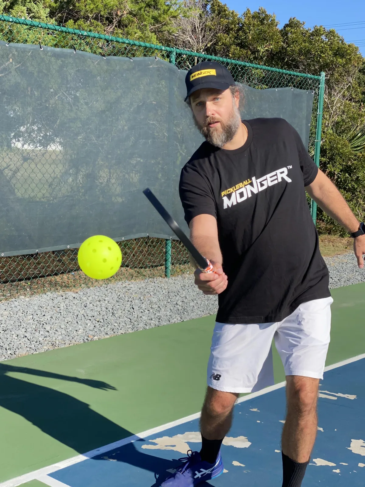 Coach Chris smiling on a pickleball court holding a paddle