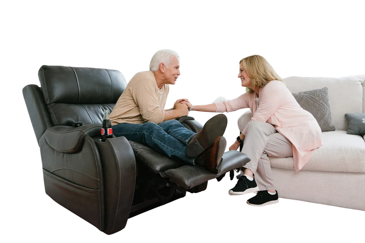 man in lift chair holds hands with family