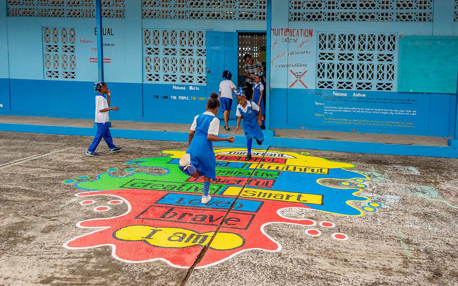 Students playing on a colorful learning values mural at Dugard Combined School in Saint Lucia